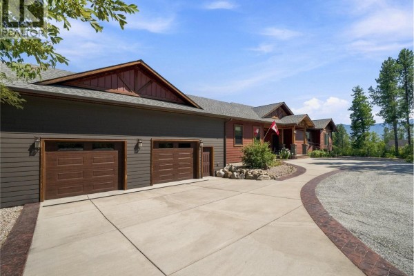 Close-up exterior view of the home's three-car garage with dark brown doors and siding. - 4780 56 Street Nw, Salmon Arm