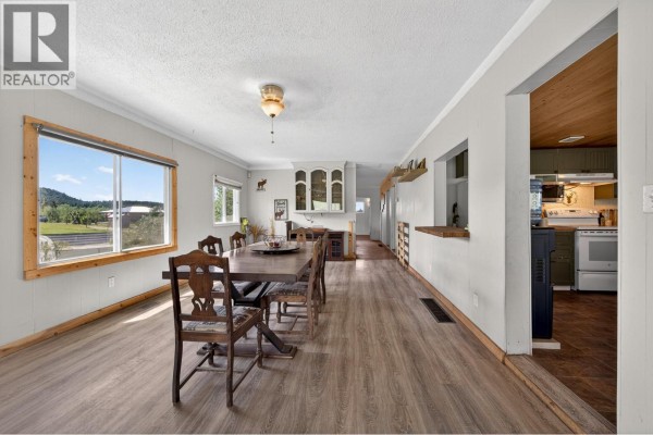 Interior view of a dining area and hallway, with a large window showing the outdoor landscape. - 4780 Harrison Road, Pritchard