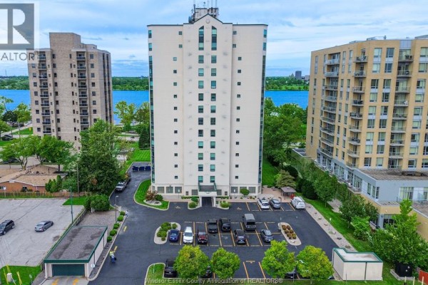 Aerial view of the apartment building with a river and trees in the background. - 4789 Riverside Unit# 504, Windsor
