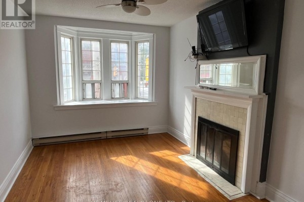 Living room with bay window, fireplace, and hardwood floors. - 479 Parliament Street, Toronto