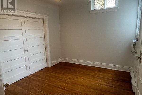 Room with double doors, hardwood floors, and a small window. - 479 Parliament Street, Toronto