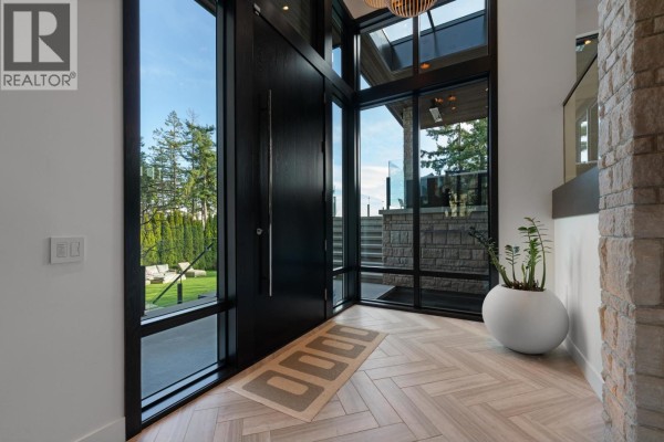 Entryway with herringbone wood flooring, large windows, and potted plant - 4799 Clovelly Walk, West Vancouver