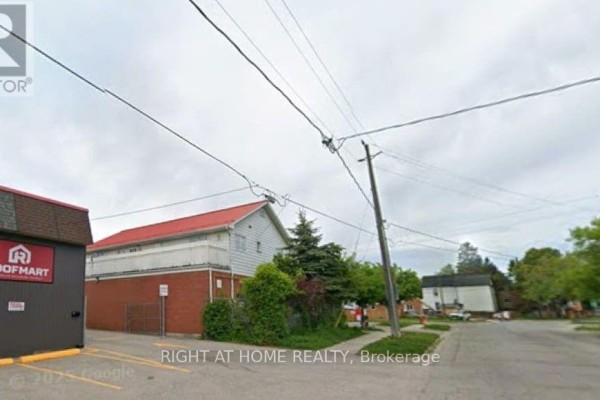 Side view of commercial buildings with red sloped roof and white siding. - 47a Town Line, Orangeville