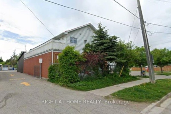 Side and rear view of commercial building with red brick base and white siding. - 47a Town Line, Orangeville