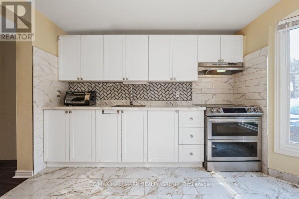 Kitchen with white cabinets, marble countertops, and stainless steel appliances. - 48 - 1005 Cloister Gardens, Ottawa