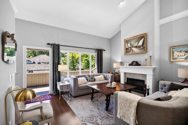Living room with grey sofas, fireplace, large sliding glass doors to balcony. - 48 3355 Morgan Creek Way, Surrey