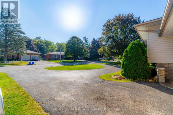 Foyer with stairs leading down to a basement and up to a living area with a couch visible. - 48 Allen Street, Tillsonburg