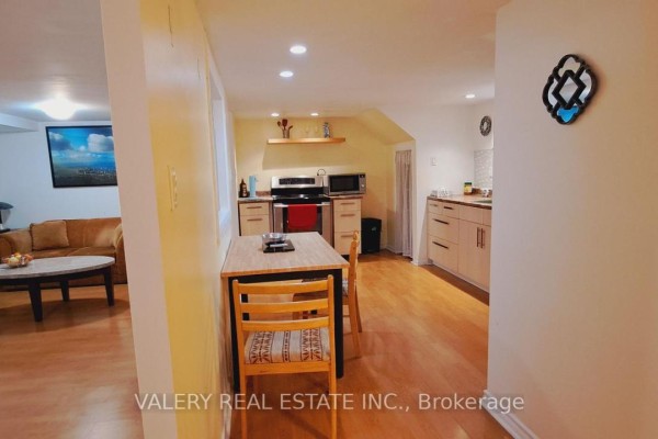 View from hallway into kitchenette, dining area, and living space with couch and coffee table. - 48 Dunkirk Road, Toronto