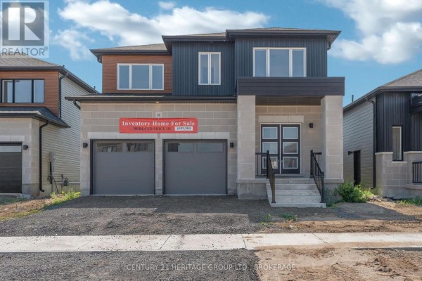 Front exterior of a two-storey house with stone and dark siding, two garage doors, and a red for sale sign. - 48 Dusenbury Drive, Loyalist
