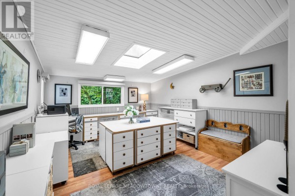 Bright multipurpose room with white furniture, wood floors, ceiling skylights, and wainscoting. - 48 Garside Avenue, Whitby