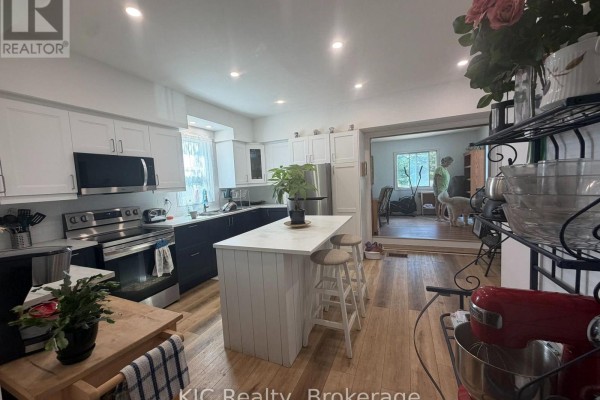 Modern kitchen with white and dark blue cabinets, stainless steel appliances, and an island. - 48 George Street E, Havelock Belmont Methuen