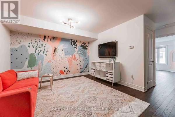 Living room with a red sofa, abstract mural, white shelving unit, and a large patterned rug. - 48 Hiawatha Court, Vaughan