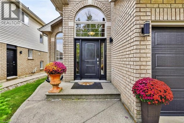 Close-up of the front entrance with a black door, arched transom window, and decorative urns. - 48 Holkham Avenue, Ancaster