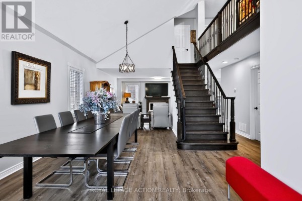 Dining area with a dark table, grey chairs, and a dark wood staircase leading upstairs. - 48 Holkham Avenue, Hamilton