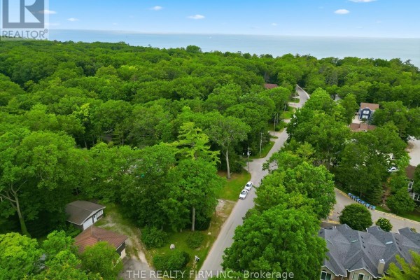 Aerial view of a treed street with a house and a detached garage. - 48 Lake Road, Lambton Shores