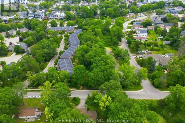 Aerial view of residential area with townhouses and houses surrounded by trees. - 48 Lake Road, Lambton Shores