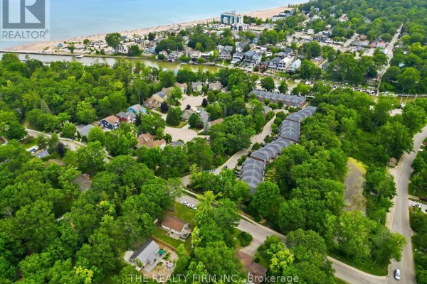 Aerial view of a wooded neighborhood with a view of the distant lake. - 48 Lake Road, Lambton Shores