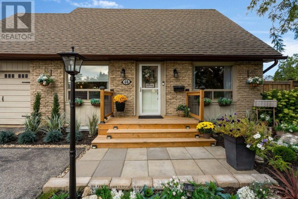 Front entrance of a brick house with a wooden porch, steps, and stone walkway. - 48 Oren Boulevard, Barrie