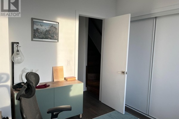 Home office with desk, chair, artwork, and a view of a staircase. - 48 Perth Avenue, Toronto