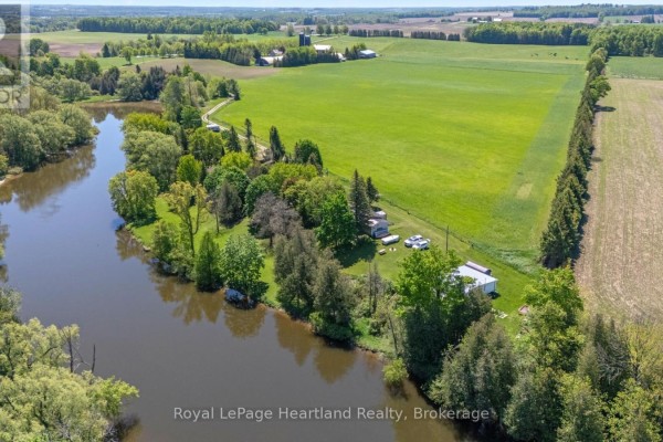 Aerial view of a rural property with a house, trees, a body of water, and surrounding farmland. - 48 Poechman Lane, Brockton