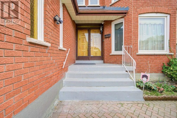 Front entryway with concrete stairs and white railings leading to double glass doors. - 48 Purcell Square, Toronto
