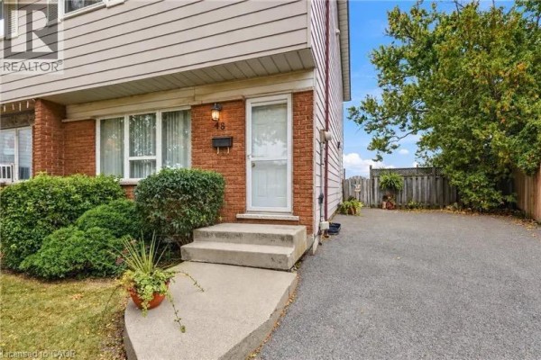 Close-up of the front entrance of the house, showing steps, a door, and landscaping. - 48 Raleigh Court, Hamilton