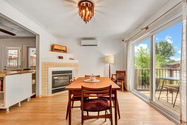 Open-concept dining area and kitchen with fireplace, wood floors, and island. - 48 Rue St-josaphat, Gatineau