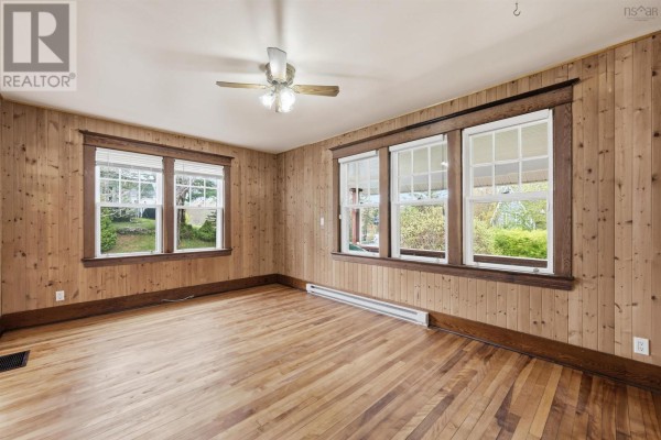 Covered wooden deck with lattice railing overlooking a grassy yard and trees under a blue sky. - 48 Shankel Road, Hubbards
