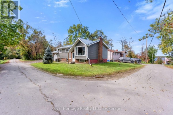 View of the house from the side with a bay window and a sloped driveway. - 48 Sliverbirch Street, Kawartha Lakes