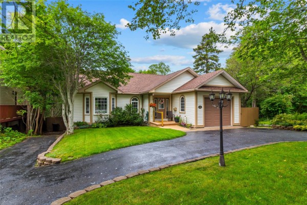 Side exterior view of a detached house with a garage and a paved driveway. - 48 Squires Avenue, St  John S