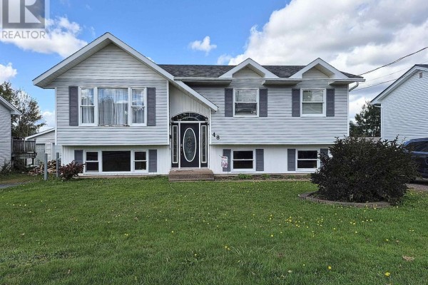 Front exterior of a light grey split-level house with a green lawn and blue sky. - 48 Townshend Avenue, Amherst