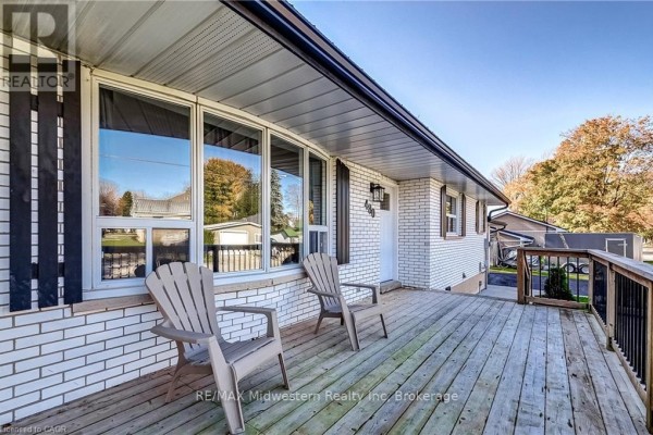 Wooden deck with two chairs on front porch of white brick house. - 480 Cavan Street, Minto