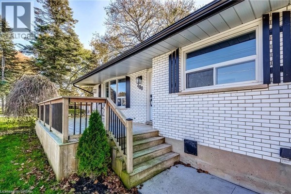 Wooden steps lead up to a porch on the side of a white brick bungalow. - 480 Cavan Street, Palmerston