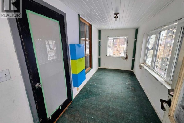 Basement room with red walls, concrete floor, and exposed studs along the bottom. - 4802 47 Street, Stettler