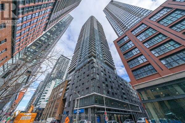 A wide shot of several tall, modern apartment buildings in a city setting, viewed from below. - 4805 - 115 Blue Jays Way, Toronto