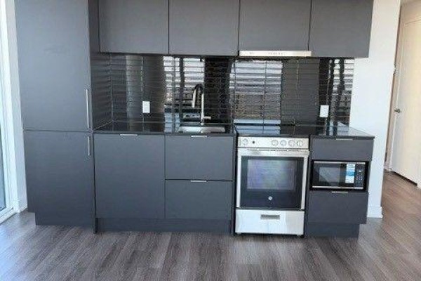 Modern grey kitchen with dark backsplash, stainless steel oven, and microwave. - 4805 - 448 Burnhamthorpe Road W, Mississauga