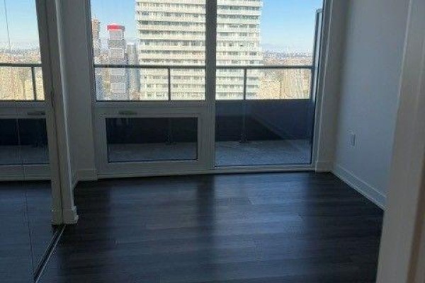 View of a bedroom with dark wood floors, white walls, and balcony access. - 4805 - 448 Burnhamthorpe Road W, Mississauga