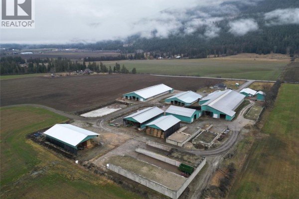 Aerial view of the farm entrance with gravel road and surrounding fields. - 4809 Back Enderby Road, Spallumcheen