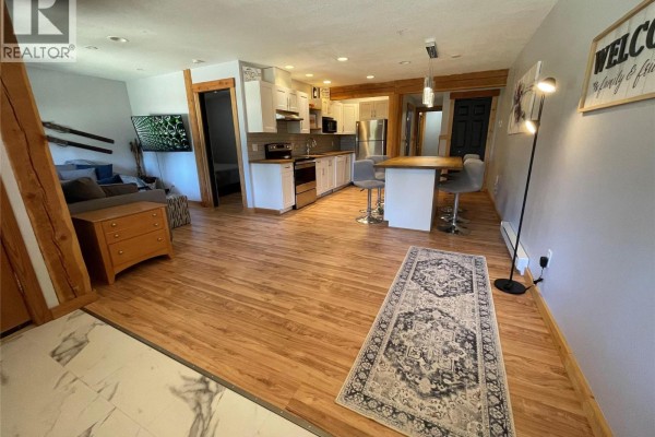 Open concept living and dining area with a kitchen island, sofa, and kitchen. - 4809 Snow Pines Road Unit# D, Big White