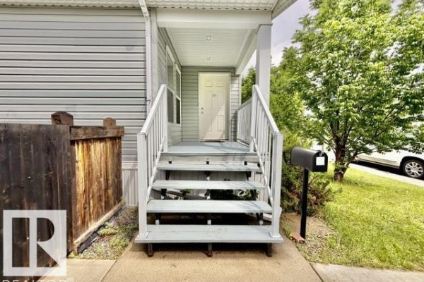 Detailed view of the porch steps, door, and mailbox of the light blue house. - 4810 48 Av, Wetaskiwin