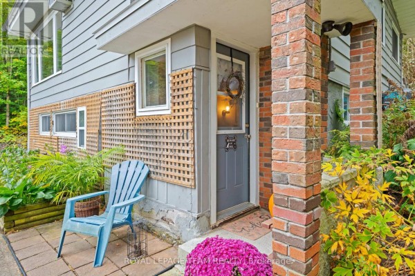 Close-up of the front door with brick pillars and a blue chair. - 4819 Opeongo Road, Ottawa