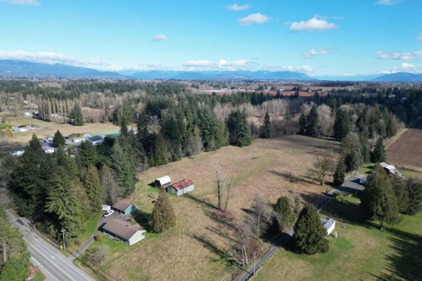 Aerial view showing house and open land with distant mountains. - 4824 248 Street, Langley