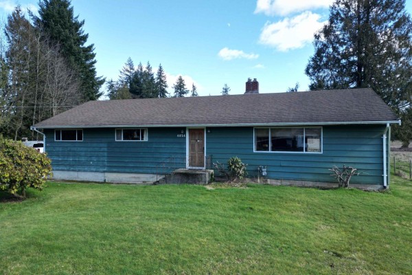 Close-up of the green house and driveway leading to the garage. - 4824 248 Street, Langley