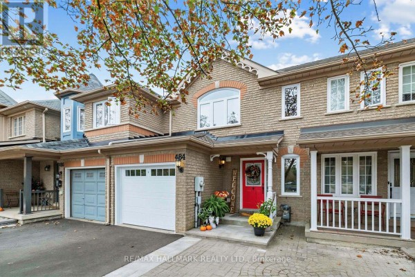 Exterior view of the townhouse entrance with a red door, porch, and brick facade. - 484 Bartholemew Drive, Newmarket