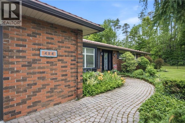 Hallway with patterned rug, leading to the front door and a view of the living area. - 484 Concession 11 Road E, Flamborough