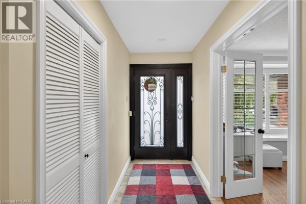 Open doorway leading to a kitchen with black cabinetry and a view of the living room. - 484 Concession 11 Road E, Flamborough