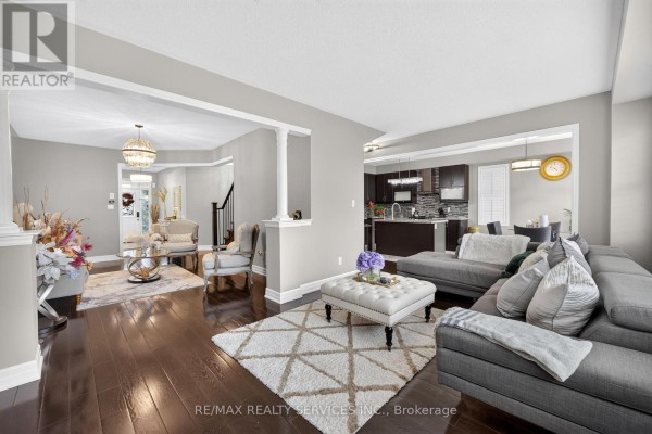 Living room with sectional sofa, ottoman, and view of modern kitchen - 484 Greenwood Drive Essa