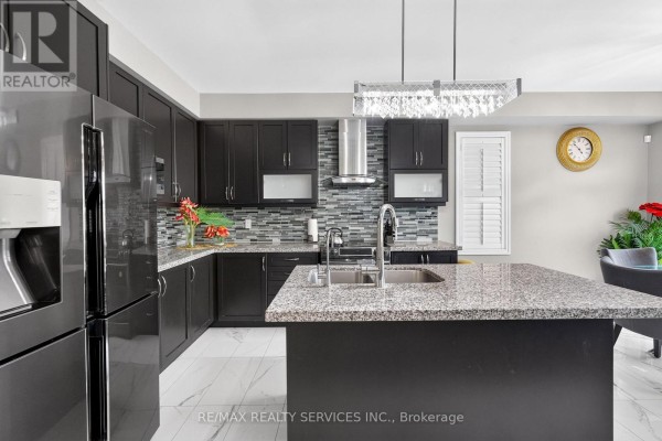 Modern kitchen with dark cabinets, granite island, and mosaic backsplash - 484 Greenwood Drive Essa