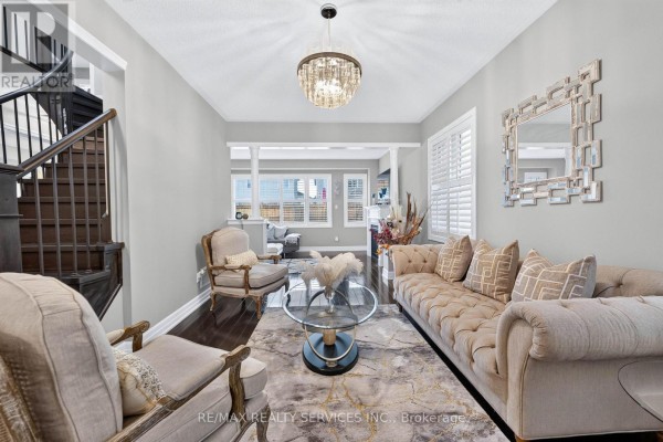 Living room with tufted sofa, ornate mirror, chandelier - 484 Greenwood Drive Essa