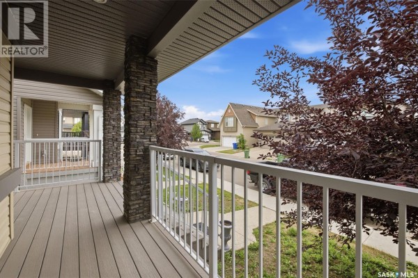 View from covered porch looking down street with houses and trees. - 4845 Liberty Street, Regina